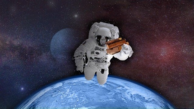 astronaut letící ve vesmíru a nesoucí knihy